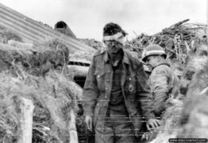 Un prisonnier allemand blessé est escorté par un policier militaire de la 1st Engineer Special Brigade. Photo : US National Archives