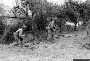 Deux soldats de la 29ème division d’infanterie inspectent un verger du secteur de Saint-Lô, les armes prêtes à faire feu. Photo : US National Archives