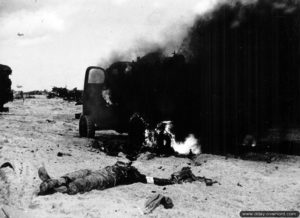 Cadavre d'un soldat américain sur la plage d'Utah Beach à proximité d'un véhicule en flamme. Photo : US National Archives