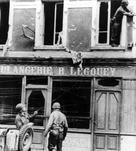 Des transmetteurs installent tant bien que mal des lignes téléphoniques dans le centre de Saint-Lô. Photo : US National Archives