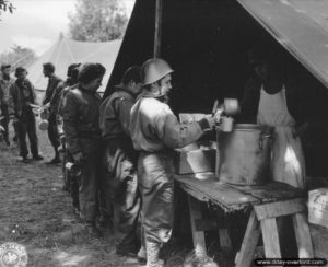 7 juillet 1944 : distribution du repas dans un campement à Vierville-sur-Mer. Photo : US National Archives