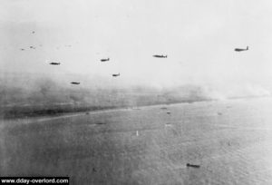 Stirling Mk 4 bombers tow Horsa gliders during Operation Mallard on June 6, 1944 shortly before 9:00 pm. The Sword Beach area is visible in the background. Photo: IWM