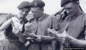 3 juin 1944 : le transmetteur John Easby à gauche et Douglas Davis au centre (tué le Jour J dans le crash de son planeur) observent les billets de la monnaie d'invasion. Photo : IWM