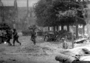 Un tir d’artillerie s’abat sur Saint-Lô et des soldats américains se mettent à couvert. Photo : US National Archives