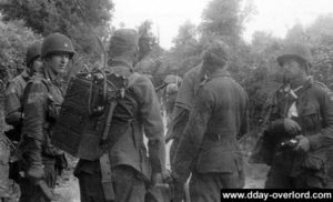 Deux prisonniers allemands (dont un équipé d'une radio SCR 300) interrogés par le colonel Ekman du 505th PIR. Photo : US National Archives