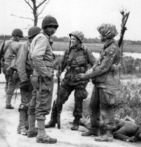Deux paras du 507th PIR le 20 juin 1944 à Cretteville Baupte avec des soldats de la 90ème division d'infanterie. Photo : US National Archives