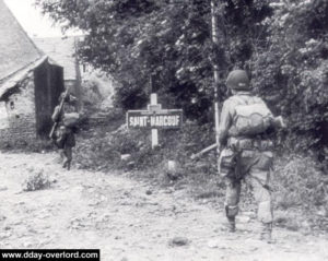Un stick de la HQ Co du 508th PIR, loin de sa DZ, progresse le Jour J à l'entrée de Saint-Marcouf. Photo : US National Archives