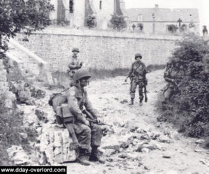 Aux abords de l'église de Saint-Marcouf, la progression est lente et éprouvante. Photo : US National Archives