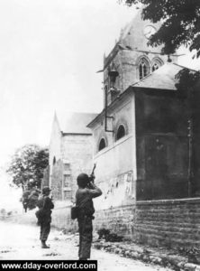 Le 6 juin 1944, une patrouille au pied du clocher de Sainte-Mère-Eglise recherche des tireurs isolés allemands. Photo : US National Archives