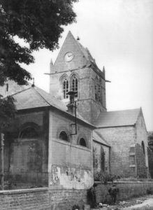 Le 6 juin 1944, une patrouille au pied du clocher de Sainte-Mère-Eglise recherche des tireurs isolés allemands. Photo : US National Archives