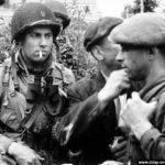 Photos of the 82nd Airborne Division during the Battle of Normandy 28 Le capitaine Kenneth Johnson de la HQ Co du 508th PIR, interroge les civils à Ravenoville. Photo : US National Archives