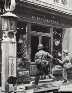 Deux paras du 505th PIR inspectent la quincaillerie Lemenicier, rue de Carentan à Sainte-Mère-Eglise. Photo : US National Archives