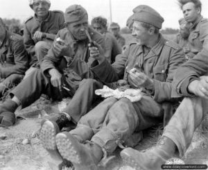 Des prisonniers allemands déjeunent avant d'embarquer à partir d'Omaha Beach à destination de la Grande-Bretagne. Photo : US National Archives