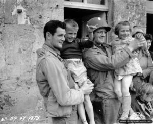 Le lieutenant Donald K. Johnson (à gauche) à Vierville avec de jeunes normands à Omaha Beach. Photo : US National Archives