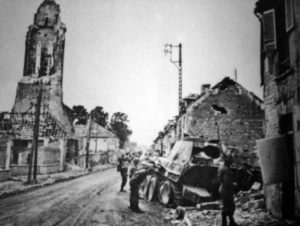 Après les combats, des soldats du Regina Rifles Regiment inspectent l’épave d’un PzKpfw V Panther détruit dans la nuit du 8 au 9 juin 1944 par le tir de Joe Lapointe au P.I.A.T. à Bretteville-l'Orgueuilleuse. Photo : IWM