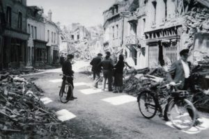 Des civils normands dans les vestiges de la rue de Caen à Lisieux en 1944. Photo : DR