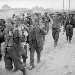 Des prisonniers allemands sont escortés le long du secteur de plage Queen à Sword Beach le 6 juin 1944. Photo : IWM