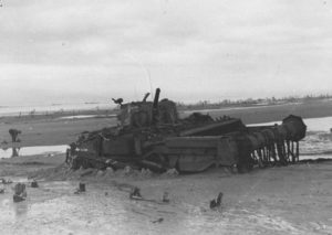 A Juno Beach après le 6 juin 1944, le char Flail de déminage baptisé "Hussar" a été abandonné sur la plage. Il appartient au B Squadron, 22nd Dragoons (Royal Armoured Corps). Son train de roulement droit semble bloqué par le sable, ce qui pourrait expliquer son abandon. Photo : US National Archives