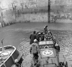 Dans le port de Grandcamp, un DUKW et des personnels de la 470th Amphibious Truck Company, 174th Quartermaster (Mobile) Battalion, dépendant du 11th Port, peu après la libération en 1944. Photo : US National Archives