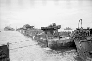 Installation des caissons Phoenix utilisés comme brise-lames au Mulberry B à Arromanches. Photo : IWM A 24168