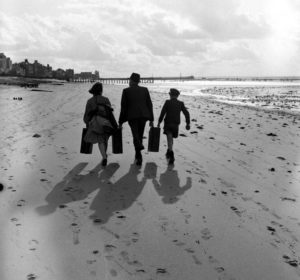 Juin 1944 : des civils transportent des jerrycans sur la plage de Grandcamp-les-Bains. Les Alliés incitaient à ce que ces nourrices leur soient rapportées et récompensaient les civils qui en apportaient. Photo : US National Archives