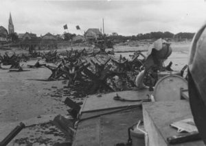 A Juno Beach, en face de Bernières-sur-Mer, les Canadiens de la 3rd (CA) Infantry Division déblayent les obstacles de plage avec un bulldozer. Photo : US National Archives