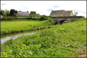 Le hameau et le pont de la Fière sur le Merderet, à quelques kilomètres de Sainte-Mère-Eglise (2015). Photo : Anabase4