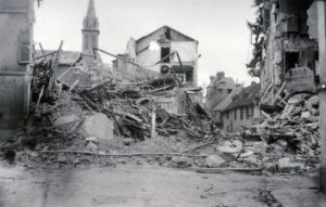 Le carrefour du boulevard Carnot et de la rue Paul Banaston à Lisieux après les bombardements de juin 1944. Le clocher de la chapelle de l'institution Frémont est visible en arrière-plan. Photo : DR