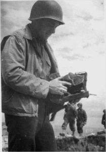 Le sergent Warden F. Lovell (165th Signal Photo Company) examine son appareil photo arraché des mains par une balle allemande lors du débarquement à la Pointe du Hoc. Photo : US National Archives