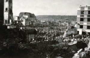 Les ruines de la rue aux Fèvres à Lisieux après les bombardements de juin 1944. Le bâtiment qui se tient encore debout en arrière-plan est l'hôtel de l'Espérance. Photo : DR