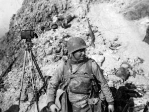 7 juin 1944 : le lieutenant-colonel James E. Rudder commandant les Rangers à la Pointe du Hoc. Il porte encore son masque à gaz et se tient à côté d'un moyen de communication visuel avec l'armada alliée. Photo : US National Archives