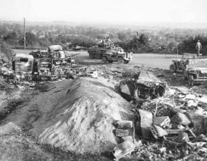 Sur les hauteurs d'Avranches, un M8 Greyhound croise des Jeep et des véhicules allemands détruits transportant du carburant. Photo : US National Archives