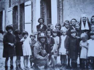 Le parachutiste américain Mike Musura, photographe officiel appartenant au 1st Battalion, 502nd Parachute Infantry Regiment, 101st Airborne Division, rend visite aux enfants d'un orphelinat d'Auvers en juin 1944. Photo : US National Archives