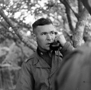 Juin 1944 : à Cerisy-la-Forêt, le Lieutenant Colonel Richard C. Carpenter, commandant le 12th (M) Field Artillery Battalion (2nd Infantry Division), donne des renseignements par téléphone à partir du poste d'observation de fortune installé dans un arbre. Il est blessé le 11 juillet 1944. Photo : US National Archives