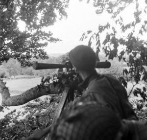 A Cerisy-la-Forêt, le Brigadier General George P. Hays (à droite), commandant la 2nd Division Artillery, observe la ligne de front à partir d'un poste d'observation de fortune installé au sommet d'un arbre, à l'aide d'un télescope binoculaire M1915A1. Photo : US National Archives