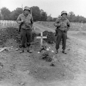 Juillet 1944 : deux Américains de la police militaire veillent la tombe du Brigadier General Theodore Roosevelt Jr., enterré le 14 juillet 1944 au cimetière temporaire n°2 de Sainte-Mère-Eglise. Photo : US National Archives