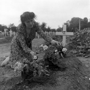 Juillet 1944 : Simone Renaud, épouse d'Alexandre Renaud, maire de Sainte-Mère-Eglise en 1944, se recueille sur la tombe du Brigadier General Theodore Roosevelt Jr., enterré le 14 juillet 1944 au cimetière temporaire n°2 de Sainte-Mère-Eglise. Photo : US National Archives