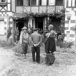 Des officiers américains échangent avec des habitants de Grandcamp-les-Bains, ici rue Gambetta. Photo : US National Archives