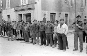 Les habitants de Grandcamp, pêcheurs pour la plupart, observent le passage des troupes américaines le long de l'actuelle rue Aristide Briand après la libération de 1944. Derrière eux, la rue de la Marine. Photo : US National Archives