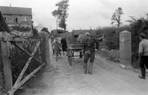 Le long de la rue du Petit Maisy à Grandcamp-les-Bains, des civils semblent rejoindre leur lieu d'habitation. Photo : US National Archives