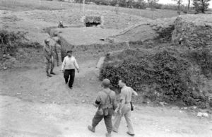 Le long de l'actuelle rue du Petit Maisy à Grandcamp-les-Bains, des militaires américains inspectent des abris creusés et confectionnés en sacs de sable. Photo : US National Archives