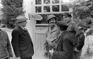 A l'extérieur de la Kommandatur de Grandcamp-les-Bains, le sergent Roland des Autels du CIC (Counter Intelligence Corps) discute avec les habitants. A gauche : Pierre Ferrari, conseiller municipal de Grandcamp. Photo : US National Archives