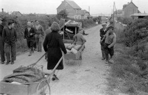 Rue du Petit Maisy à Grandcamp-les-Bains, des civils semblent rejoindre leur habitation après les combats. Photo : US National Archives