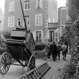 Le sergent Roland des Autels (sans son casque) du CIC (Counter Intelligence Corps) s'entretient avec des habitants de la commune de Grandcamp-les-Bains. Avec la canne, Pierre Ferrari, conseiller municipal de Grandcamp-les-Bains. Photo : US National Archives