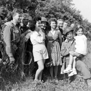Des soldats américains posent avec de jeunes femmes françaises et une enfant, dans le secteur d'Avranches. Photo : US National Archives