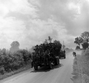 Des prisonniers allemands sont transportés à bord d'un camion GMC dans le secteur d'Avranches, escortés par une Jeep et quelques militaires américains de la 3rd (US) Army. Photo : US National Archives