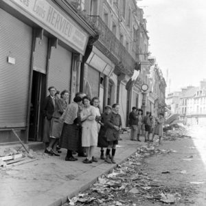 Des habitants de Carentan observent les troupes américaines, Place de la République, peu après la libération. Photo : US National Archives