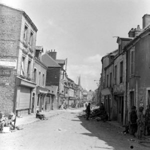 Épuisés par les éprouvants combats qu'ils viennent de livrer, des parachutistes américains de la 101st (US) Airborne Division se reposent le long de la rue Holgate à Carentan. Photo : US National Archives