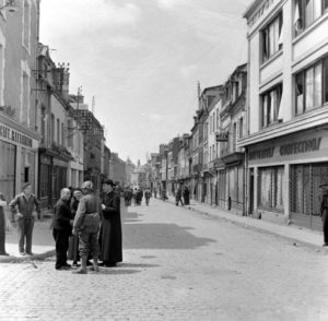 Rue Holgate à Carentan, des civils s'entretiennent avec un officier américain, peu après la libération. Photo : US National Archives