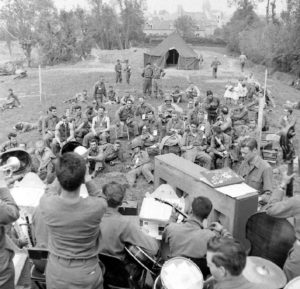 Concert organisé pour les pensionnaires de l'infirmerie tenue par le 308th Medical Battalion, 83rd (US) Infantry Division au numéro 45 rue Holgate à Carentan, dans l'hôtel Durand de la Borderie-Énouf. Photo : US National Archives